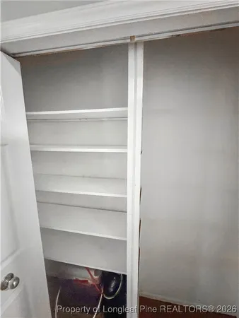 a view of walk in closet with empty racks