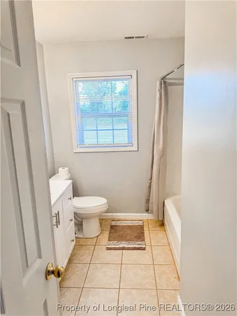 a bathroom with a toilet a sink a bath tub and a window