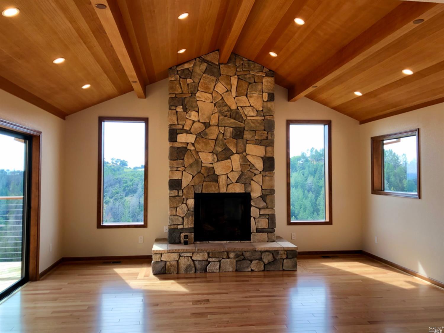 2278 Mark West Springs Road Santa Rosa, CA 95404 - Photo 1 of 1 an empty room with windows fireplace and wooden floor