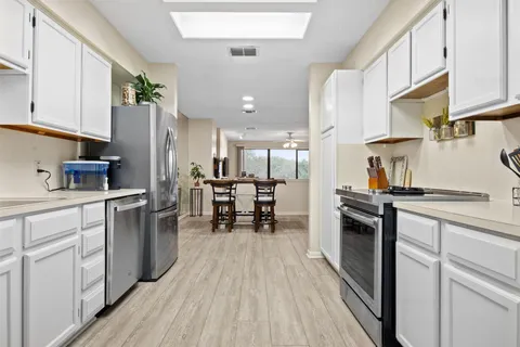 a kitchen with granite countertop a sink appliances cabinets and counter space