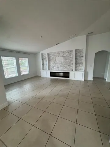 a view of a livingroom with kitchen and window