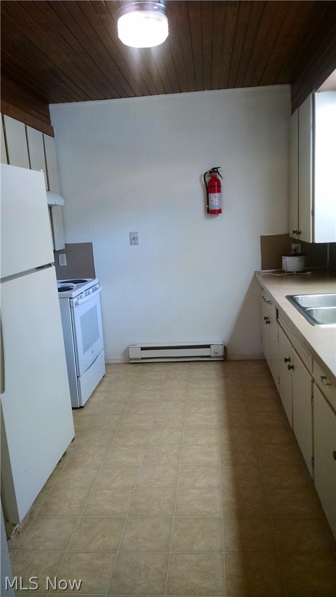 Kitchen ceiling and foyer entrance walls are stained tongue and groove wood