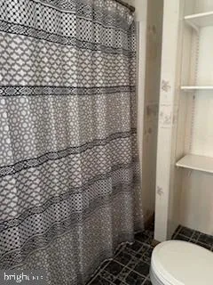 a bathroom with a toilet and a shower