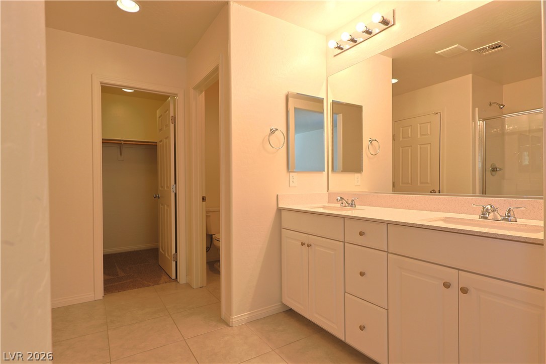 8663 Reynolds Spring Street Las Vegas, NV 89178 - Photo 20 of 32 Clean lines and a spacious dual vanity define this functional master bathroom layout.