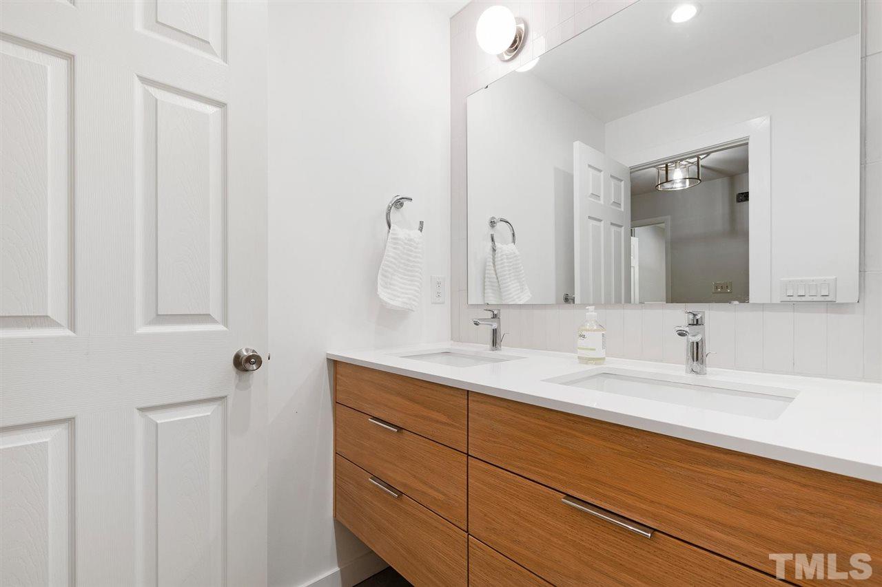 3316 Mesa Court Raleigh, NC 27607 - Photo 22 of 30 a bathroom with a double vanity sink and a mirror