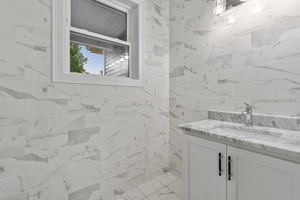 186 Justice Hill Road, Unit OAKMONT Sterling, MA 01564 - Photo 12 of 34 a bathroom with a granite countertop sink and mirror