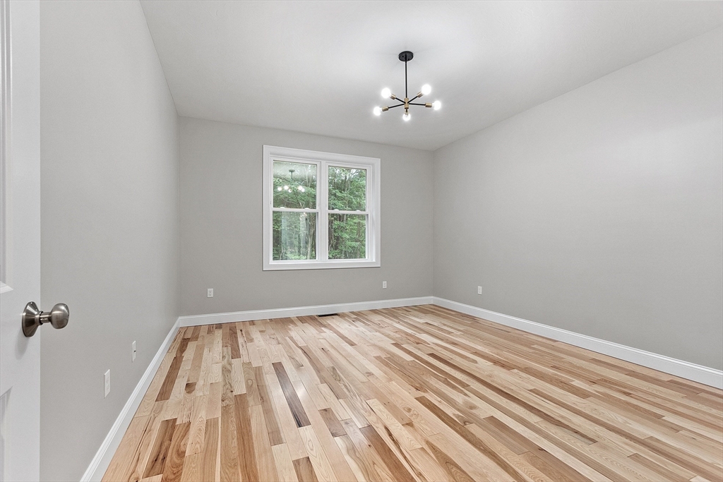 186 Justice Hill Road, Unit OAKMONT Sterling, MA 01564 - Photo 16 of 34 wooden floor in an empty room with a window