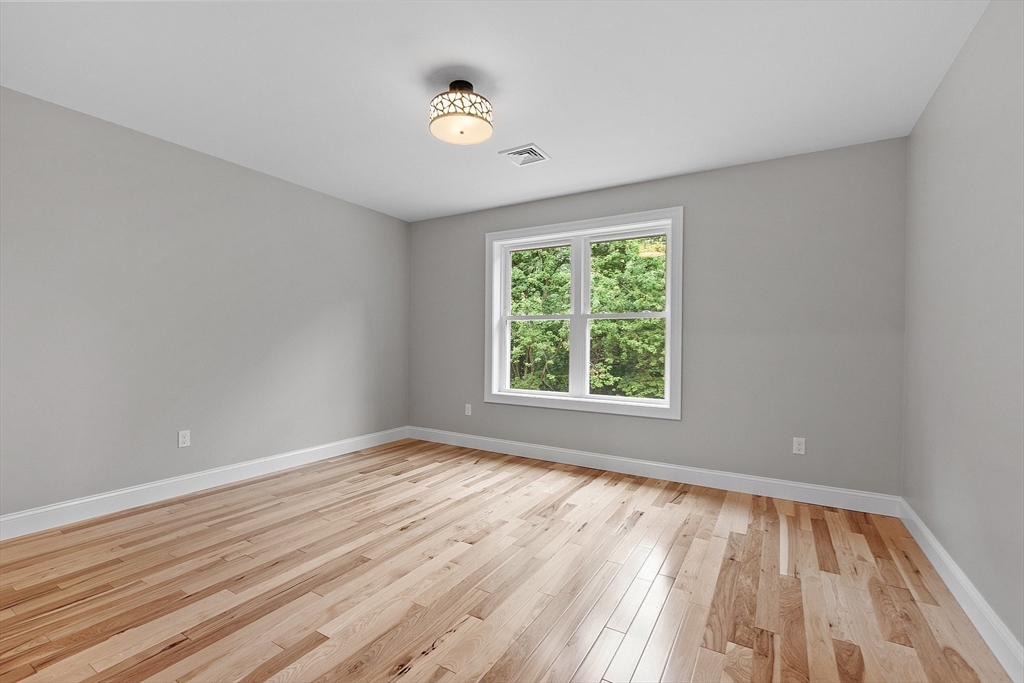 186 Justice Hill Road, Unit OAKMONT Sterling, MA 01564 - Photo 26 of 34 an empty room with wooden floor and windows