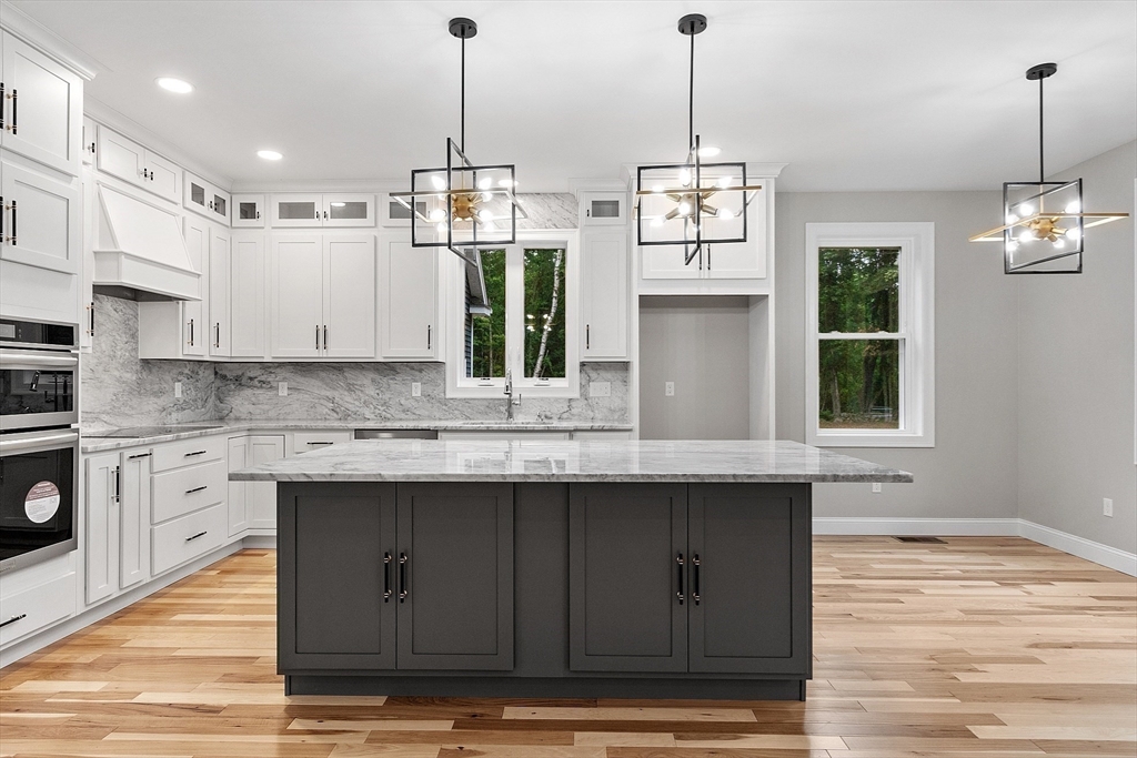 186 Justice Hill Road, Unit OAKMONT Sterling, MA 01564 - Photo 7 of 34 a kitchen with kitchen island granite countertop a sink a counter space appliances and cabinets