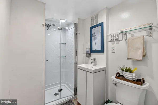 a bathroom with a shower a sink and mirror