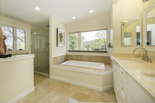23 Mason Street Lexington, MA 02421 - Photo 10 of 24 a bathroom with a granite countertop sink a bathtub and next to a window