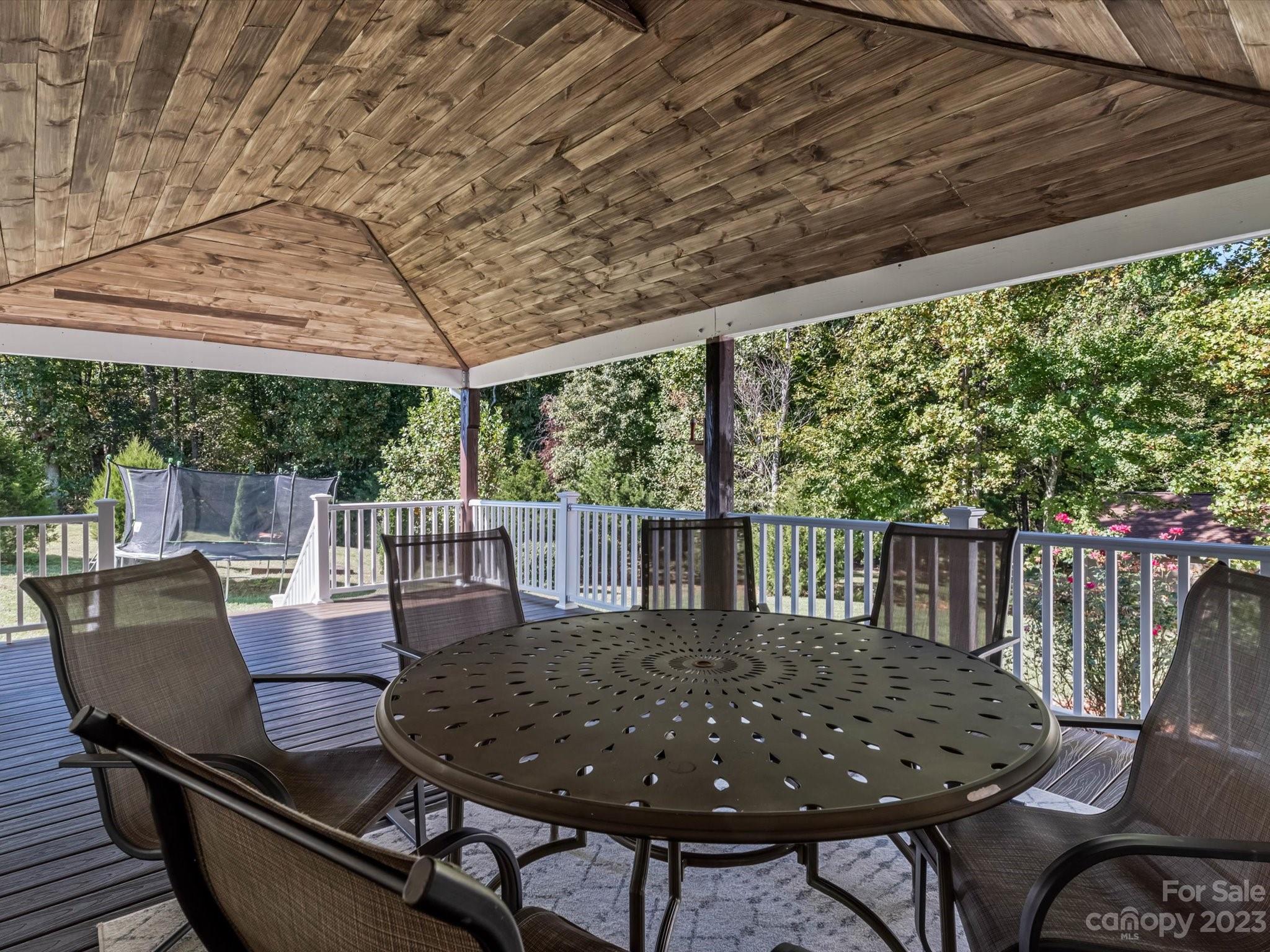125 Boulder Ridge Drive State Road, NC 28676 - Photo 25 of 39 a view of a patio with table and chairs with wooden floor and fence