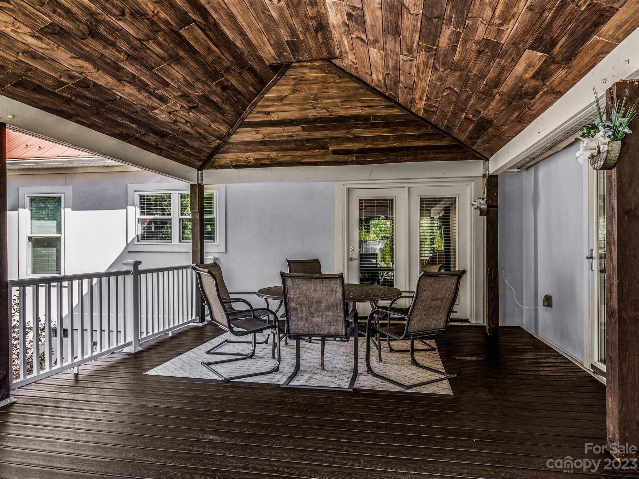 125 Boulder Ridge Drive State Road, NC 28676 - Photo 26 of 39 a view of a roof deck with table and chairs and wooden floor