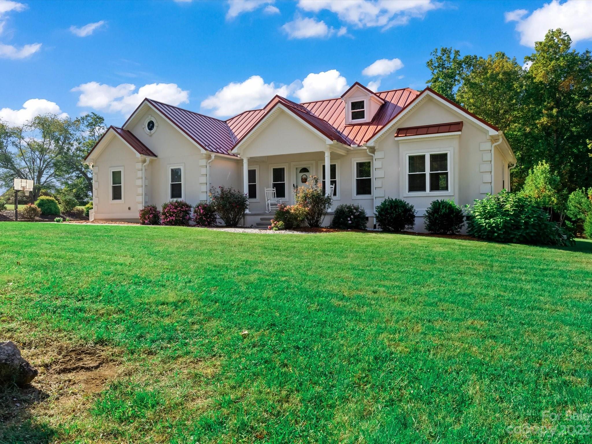 125 Boulder Ridge Drive State Road, NC 28676 - Photo 3 of 39 a front view of a house with a garden and yard