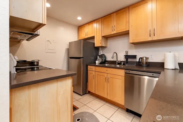 a kitchen with stainless steel appliances granite countertop a refrigerator a sink a stove and island