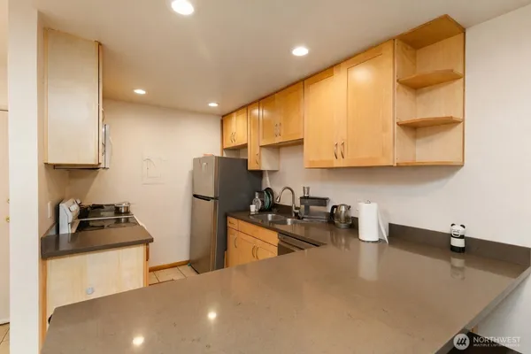 a kitchen with stainless steel appliances granite countertop a refrigerator and a stove