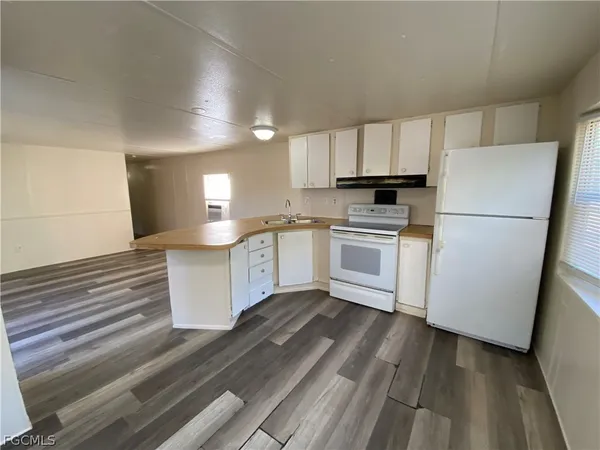 a kitchen with a refrigerator a stove top oven and cabinets