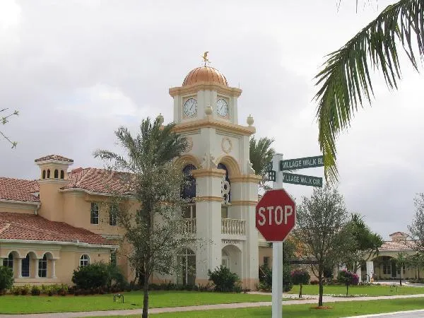 a front view of a building with yard and sign board