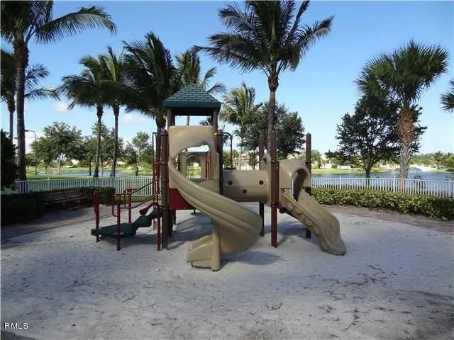 a view of a park with a slide swing and a slide