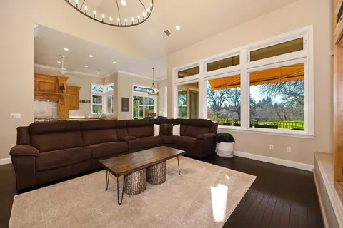a view of living room kitchen with stainless steel appliances granite countertop cabinets and wooden floor