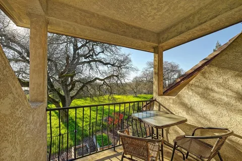 a view of a patio with a table and chairs under an umbrella