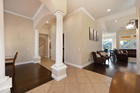 a living room with furniture a fireplace and a chandelier