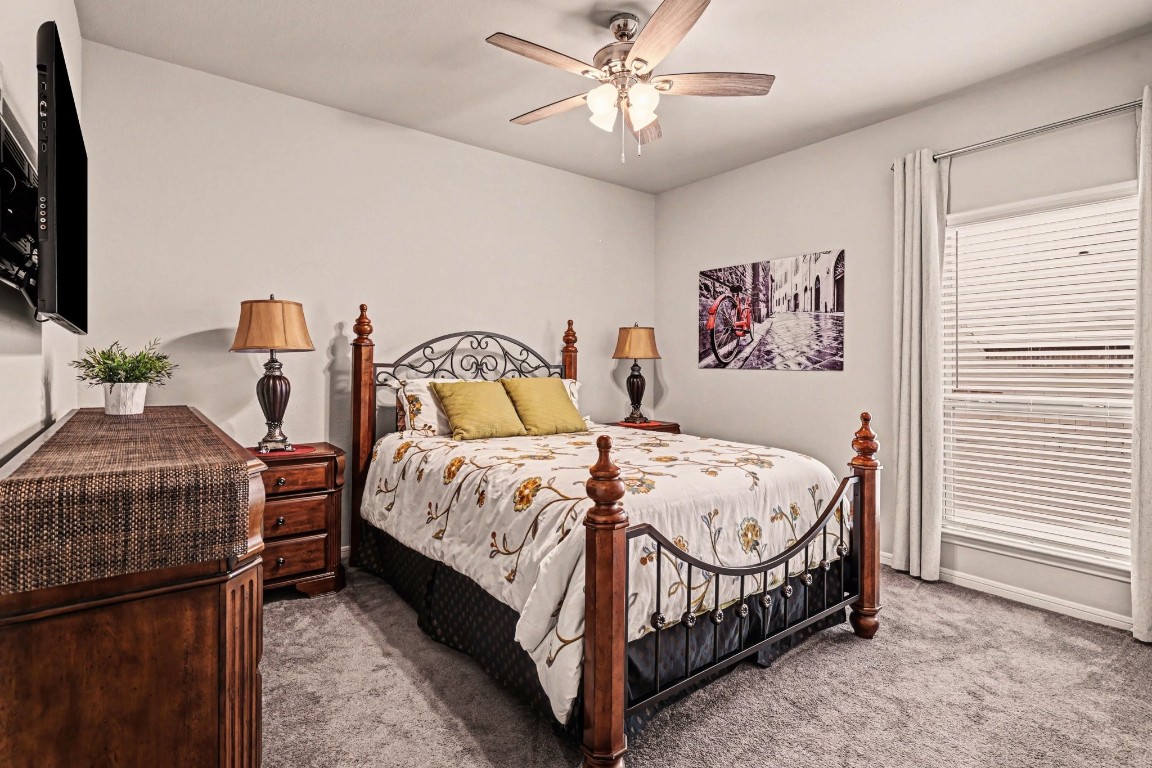 320 Red Maple Lane Conroe, TX 77304 - Photo 16 of 27 a bedroom with a bed and a chandelier