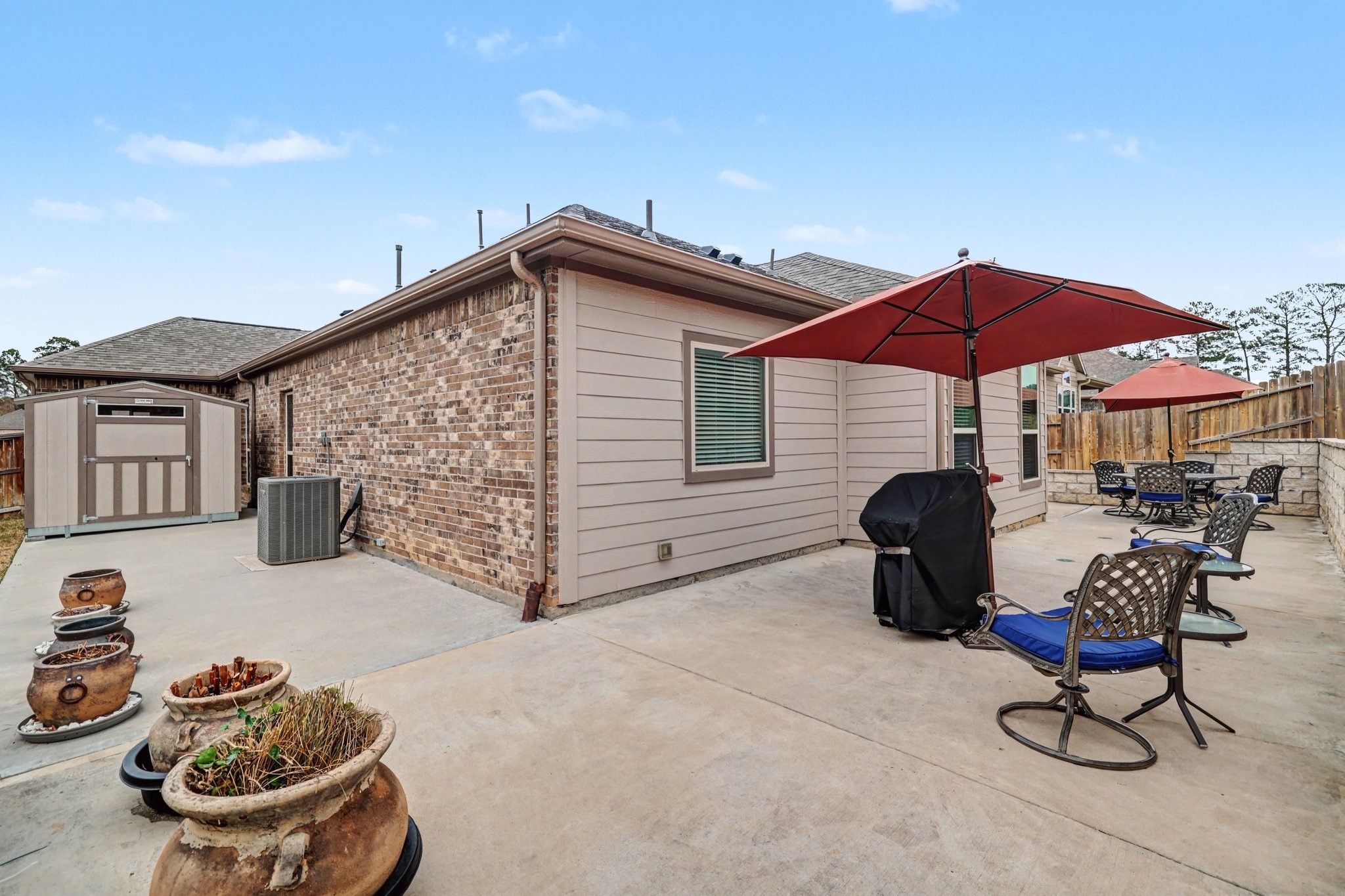 320 Red Maple Lane Conroe, TX 77304 - Photo 21 of 27 a view of a patio with table and chairs under an umbrella