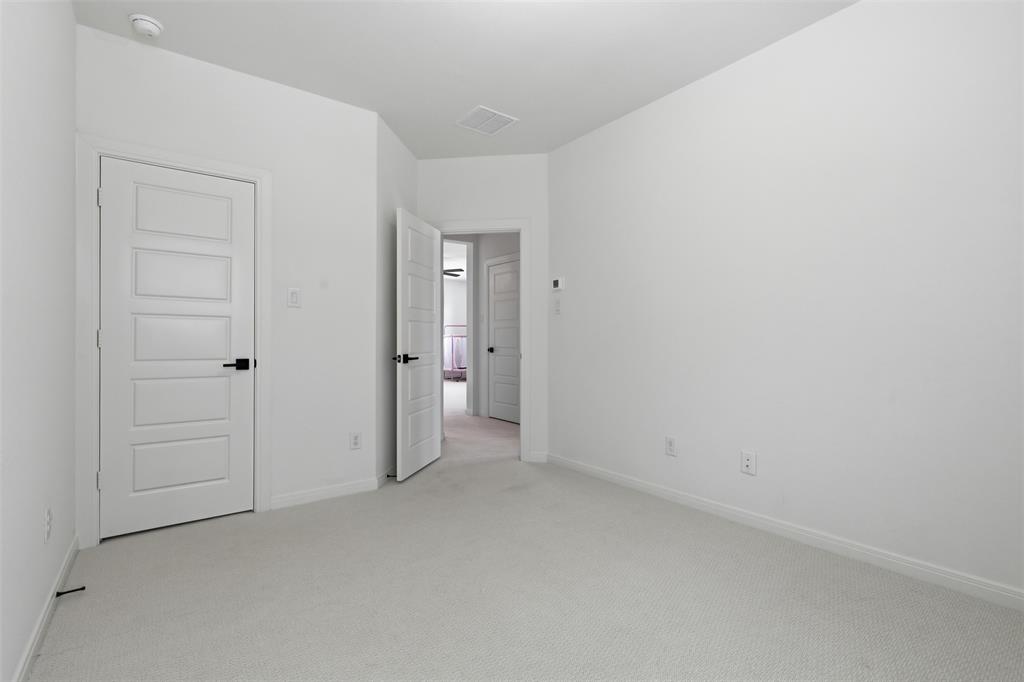 15413 Short Rdg Lane Fort Worth, TX 76008 - Photo 28 of 39 Spacious room with new carpet, crisp white walls, and a five-panel interior door with matte black hardware