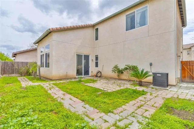 a backyard of a house with plants and wooden fence