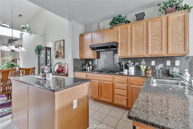 a kitchen with stainless steel appliances granite countertop a sink dishwasher and cabinets with wooden floor