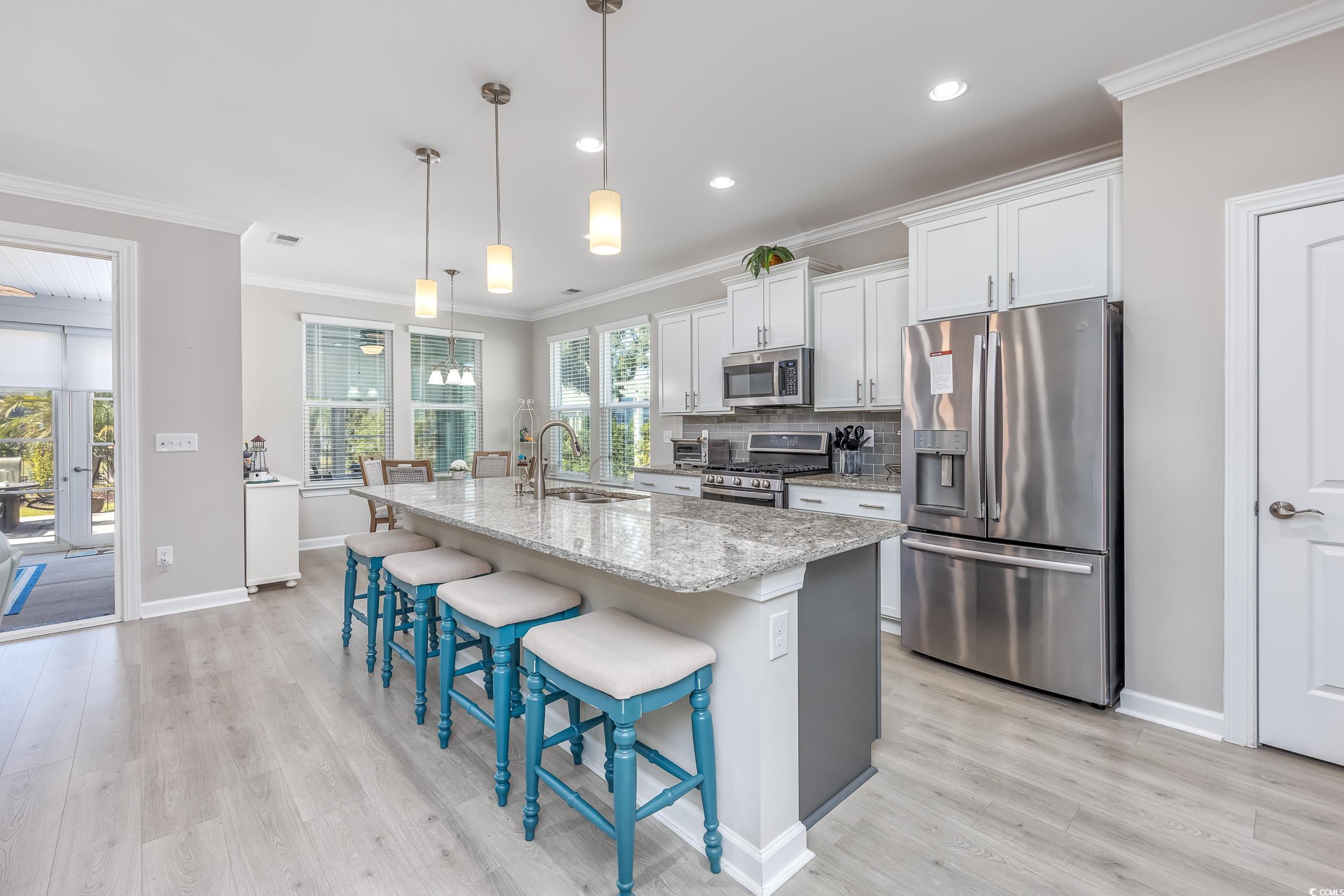 311 Switchgrass Loop Little River, SC 29566 - Photo 12 of 38 Kitchen with light stone countertops, sink, white