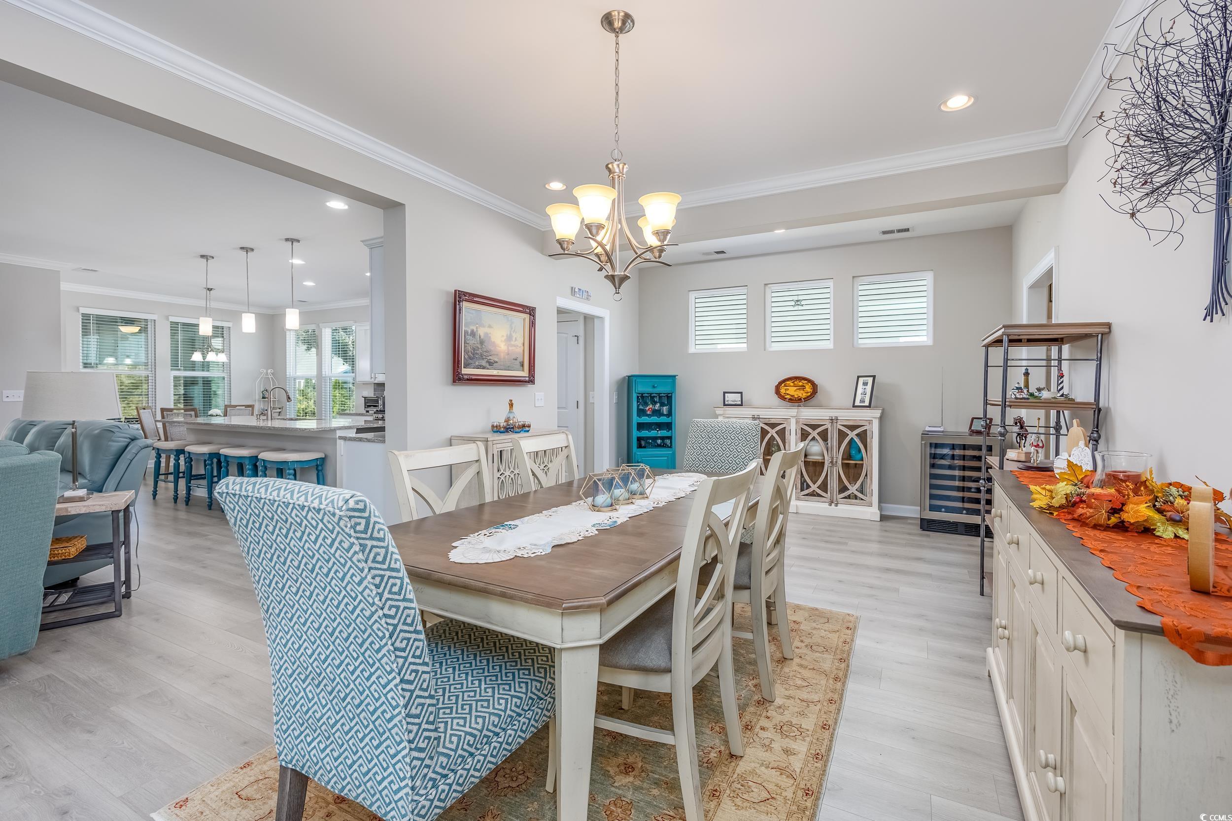 311 Switchgrass Loop Little River, SC 29566 - Photo 9 of 38 Dining room featuring crown molding, light hardwoo
