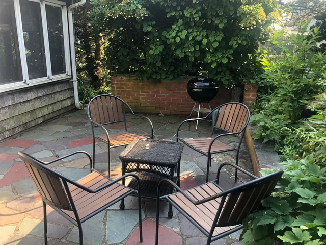 a backyard of a house with barbeque oven table and chairs