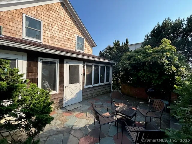 a view of house with backyard and sitting area
