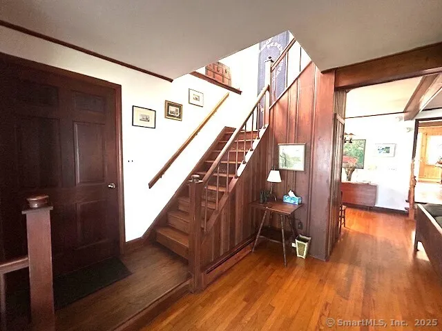 a view of entryway and hall with wooden floor