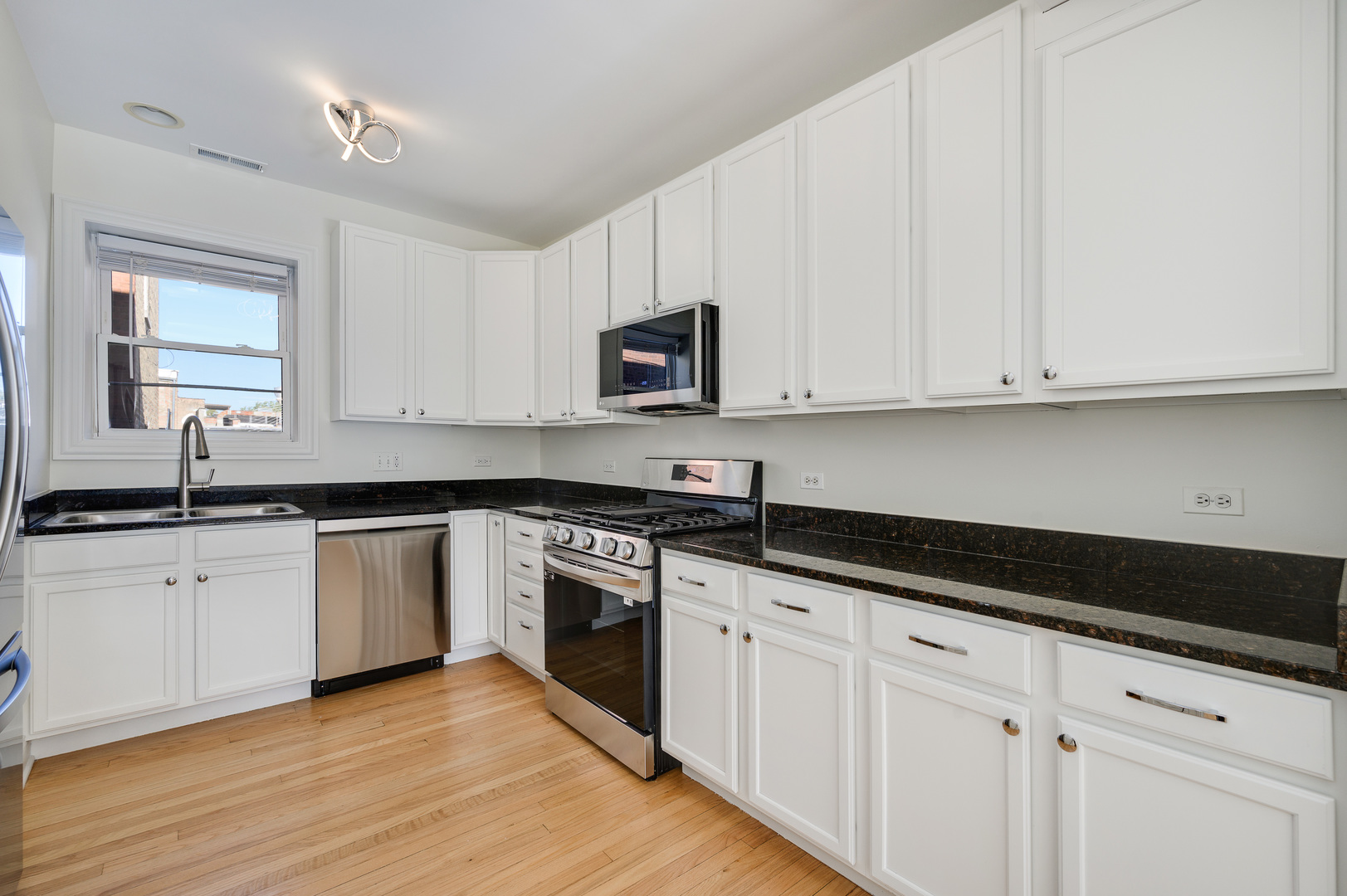 1544 West Sherwin Avenue, Unit 2N Chicago, IL 60626 - Photo 6 of 19 a kitchen with granite countertop white cabinets and a stove