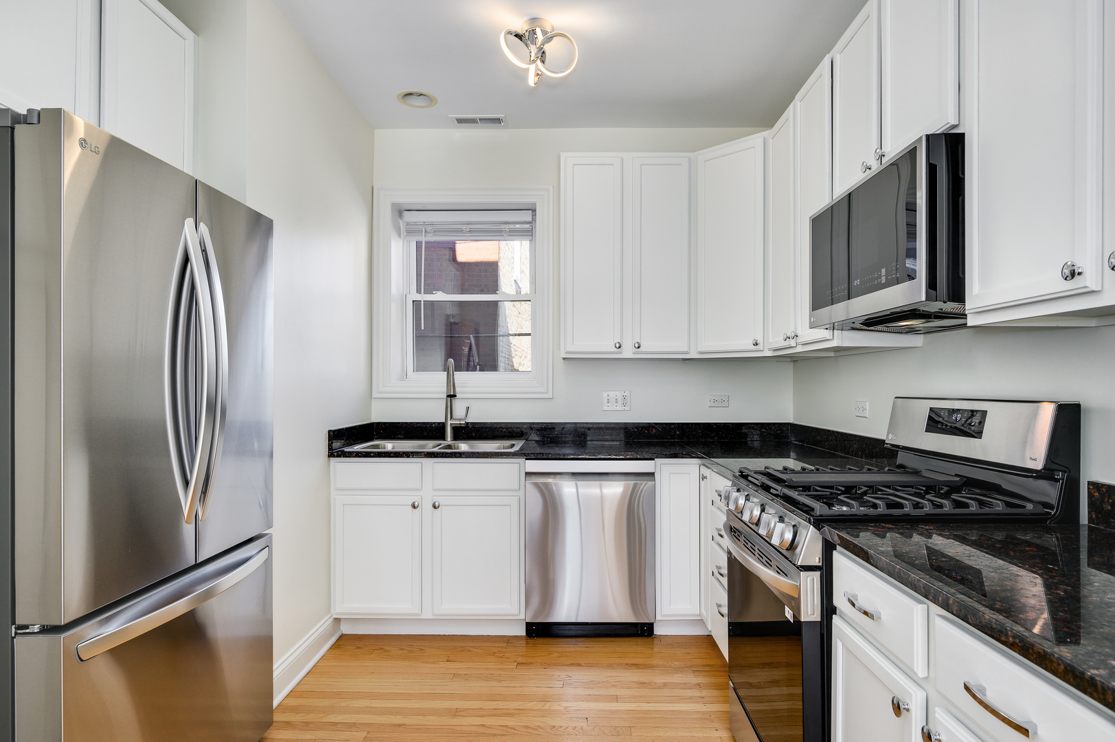 1544 West Sherwin Avenue, Unit 2N Chicago, IL 60626 - Photo 7 of 19 a kitchen with stainless steel appliances granite countertop a refrigerator stove and microwave