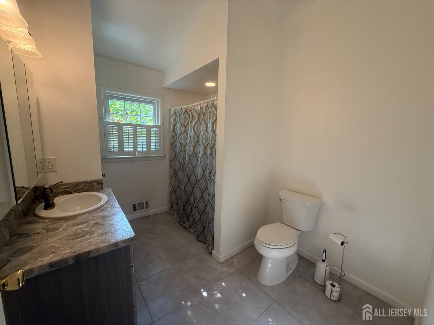 42 Boulevard East Old Bridge, NJ 07735 - Photo 9 of 14 a bathroom with a granite countertop sink a toilet and a mirror