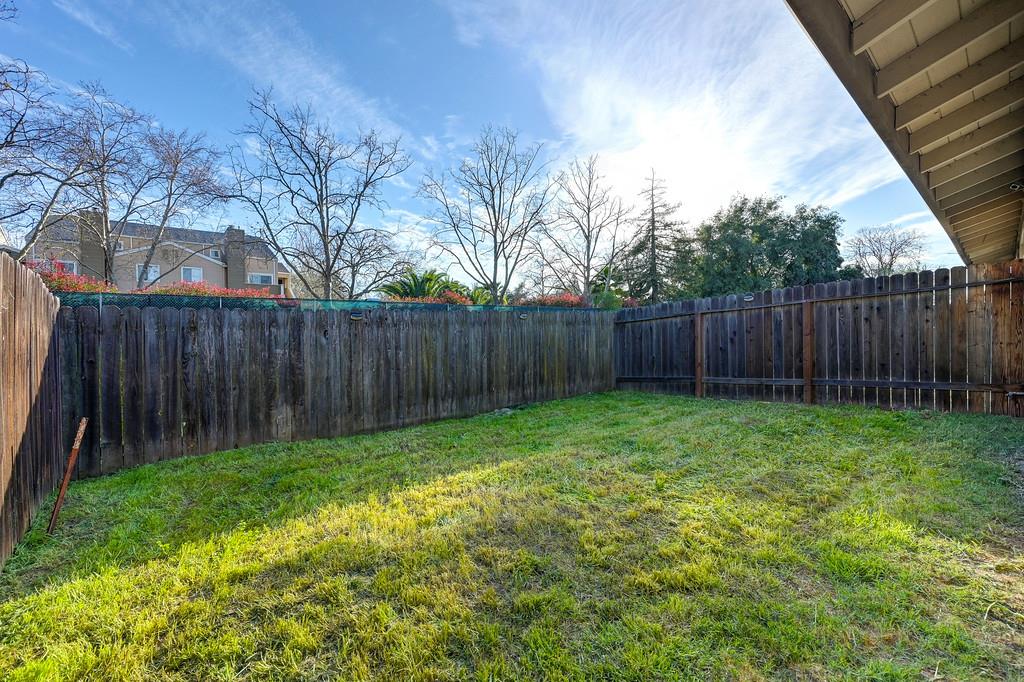 1052 Clinton Road Sacramento, CA 95825 - Photo 24 of 52 a view of a backyard with large trees and wooden fence