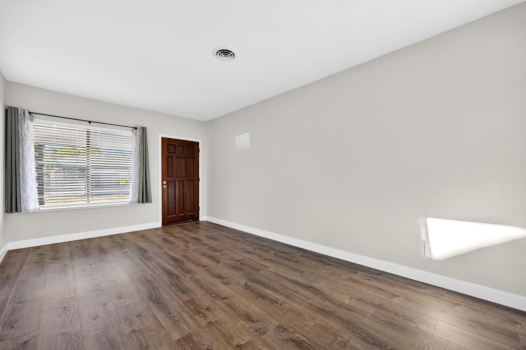 1052 Clinton Road Sacramento, CA 95825 - Photo 31 of 52 a view of an empty room with wooden floor and a window