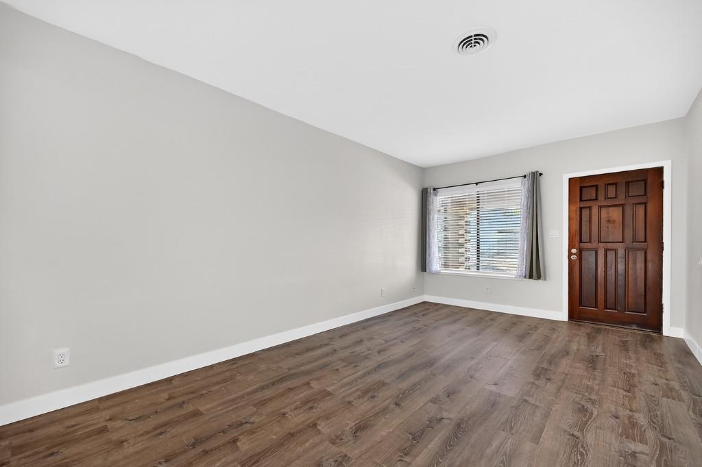 1052 Clinton Road Sacramento, CA 95825 - Photo 33 of 52 a view of an empty room with wooden floor and a window