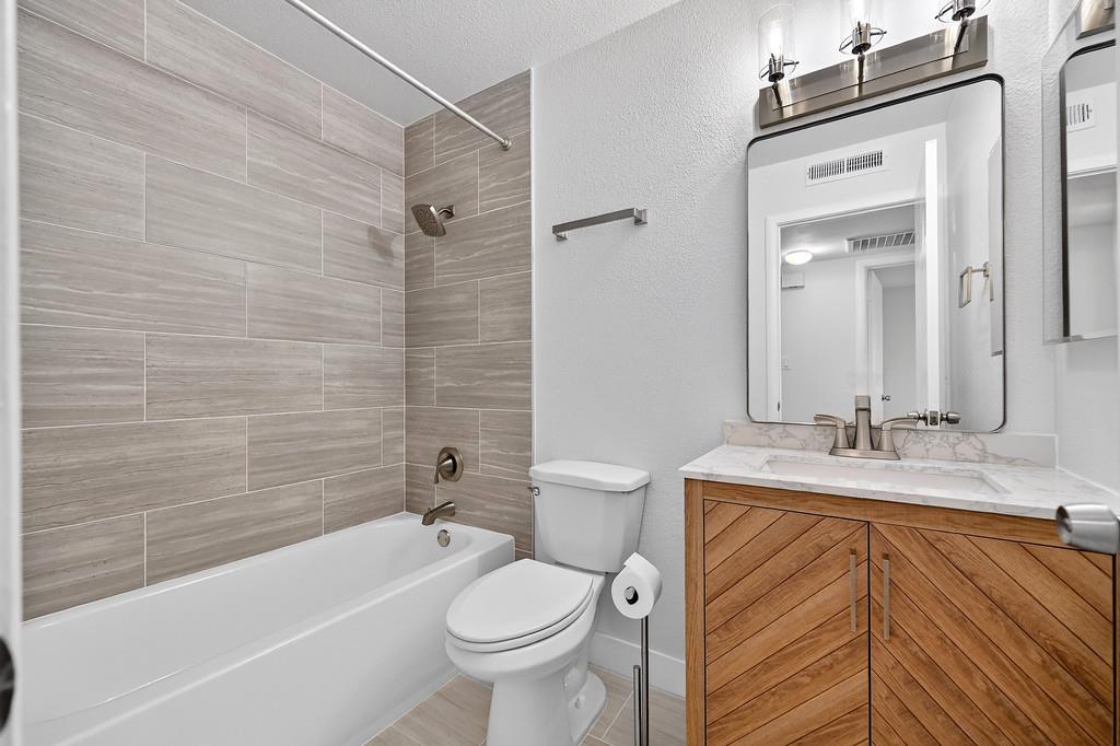 1052 Clinton Road Sacramento, CA 95825 - Photo 43 of 52 a bathroom with a sink a toilet a mirror a bathtub and shower