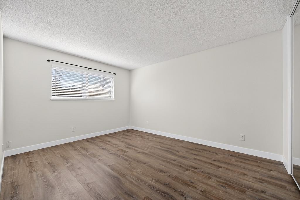 1052 Clinton Road Sacramento, CA 95825 - Photo 44 of 52 a view of an empty room with wooden floor and a window