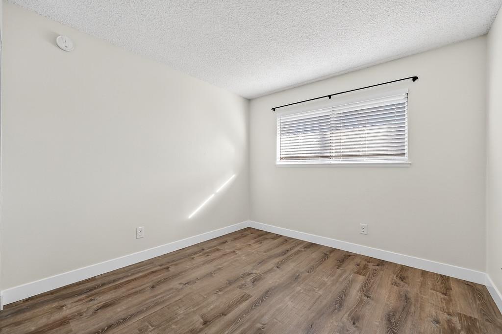 1052 Clinton Road Sacramento, CA 95825 - Photo 46 of 52 an empty room with wooden floor and windows