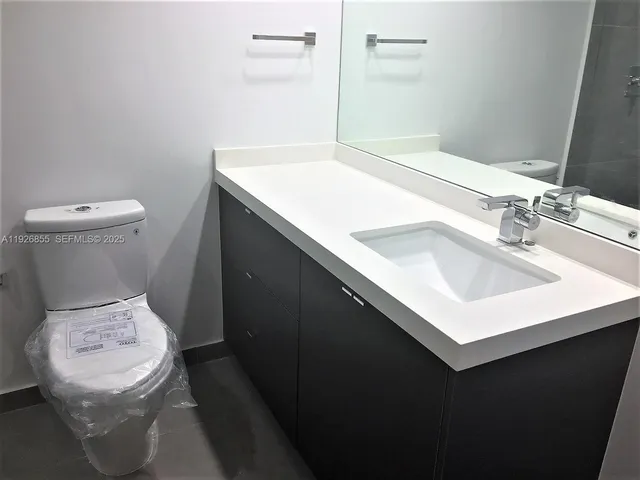 a bathroom with a sink toilet and a mirror