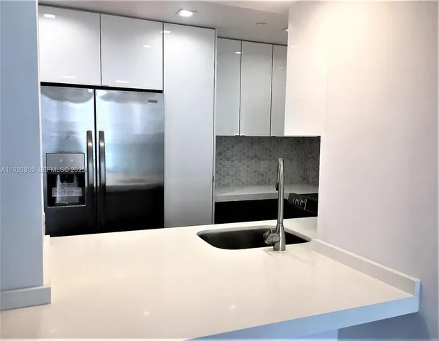 a kitchen with stainless steel appliances a refrigerator and a sink