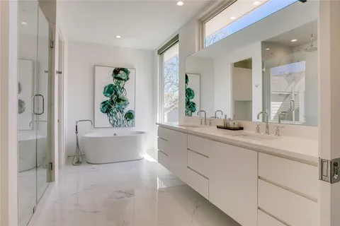a en suite bathroom with a double vanity sink and a mirror