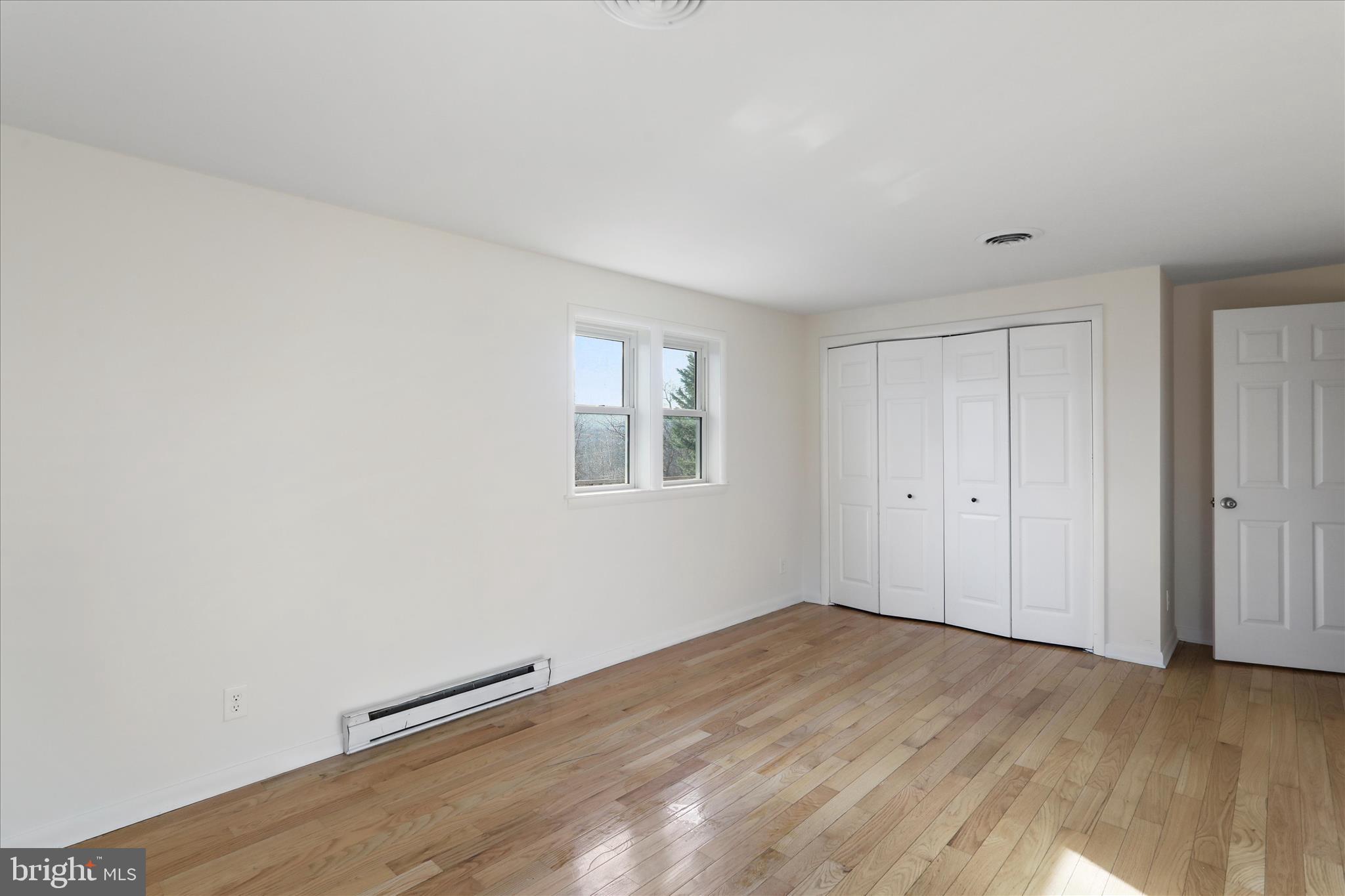 13 Oriole Circle Berkeley Springs, WV 25411 - Photo 19 of 36 a view of an empty room with wooden floor and a window