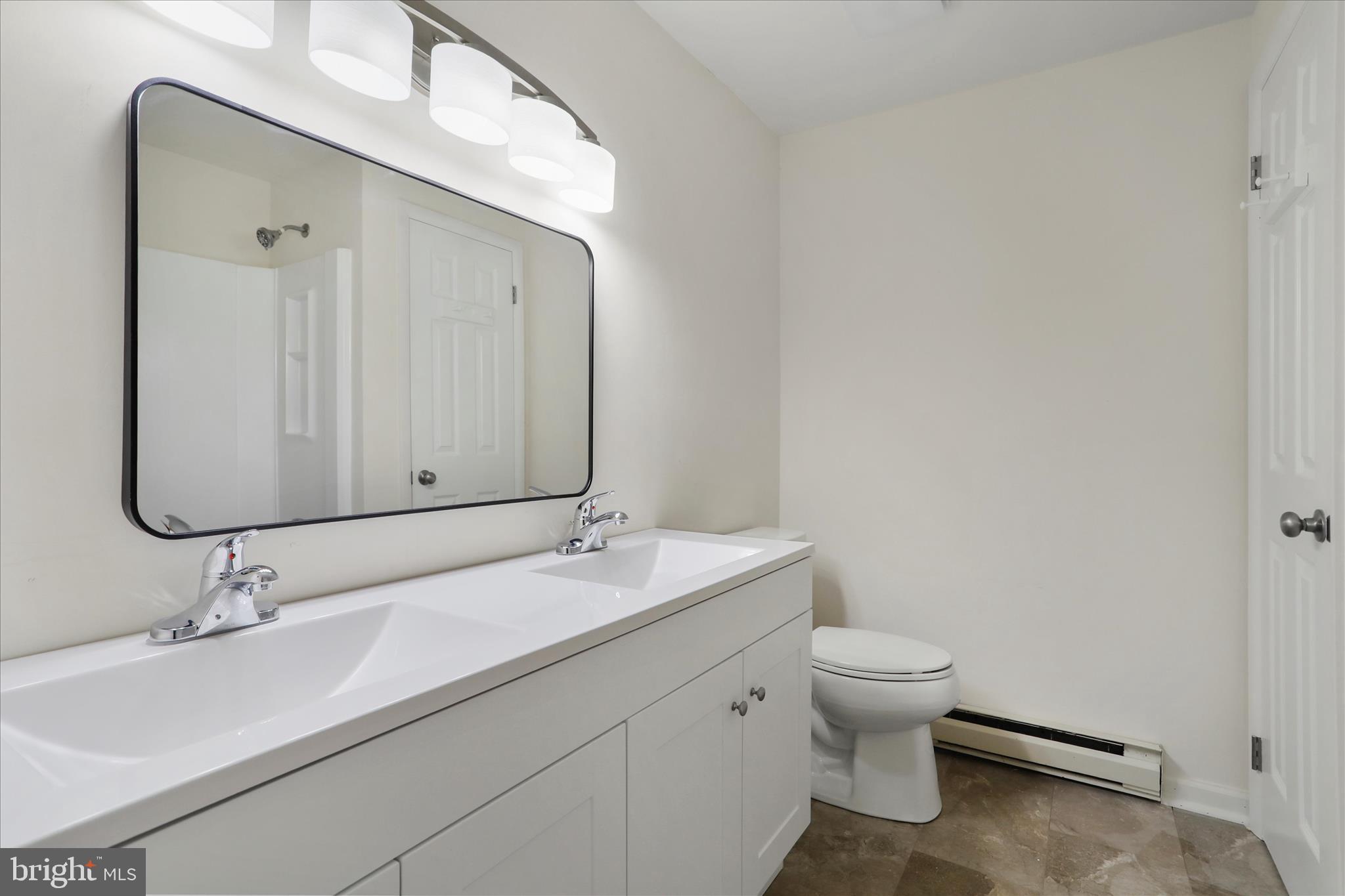 13 Oriole Circle Berkeley Springs, WV 25411 - Photo 23 of 36 a bathroom with a granite countertop sink a toilet and a mirror